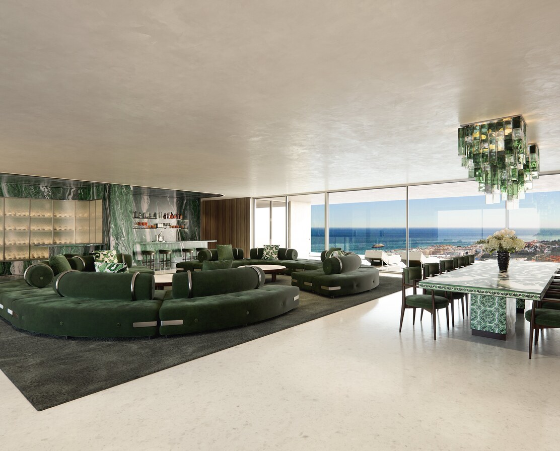 The living room: green velvet sofas, green marble and a Murano chandelier, the sea beyond.