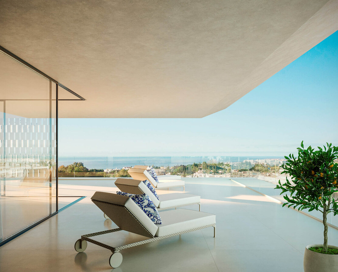 A terrace with loungers and a citrus tree, the sea below.
