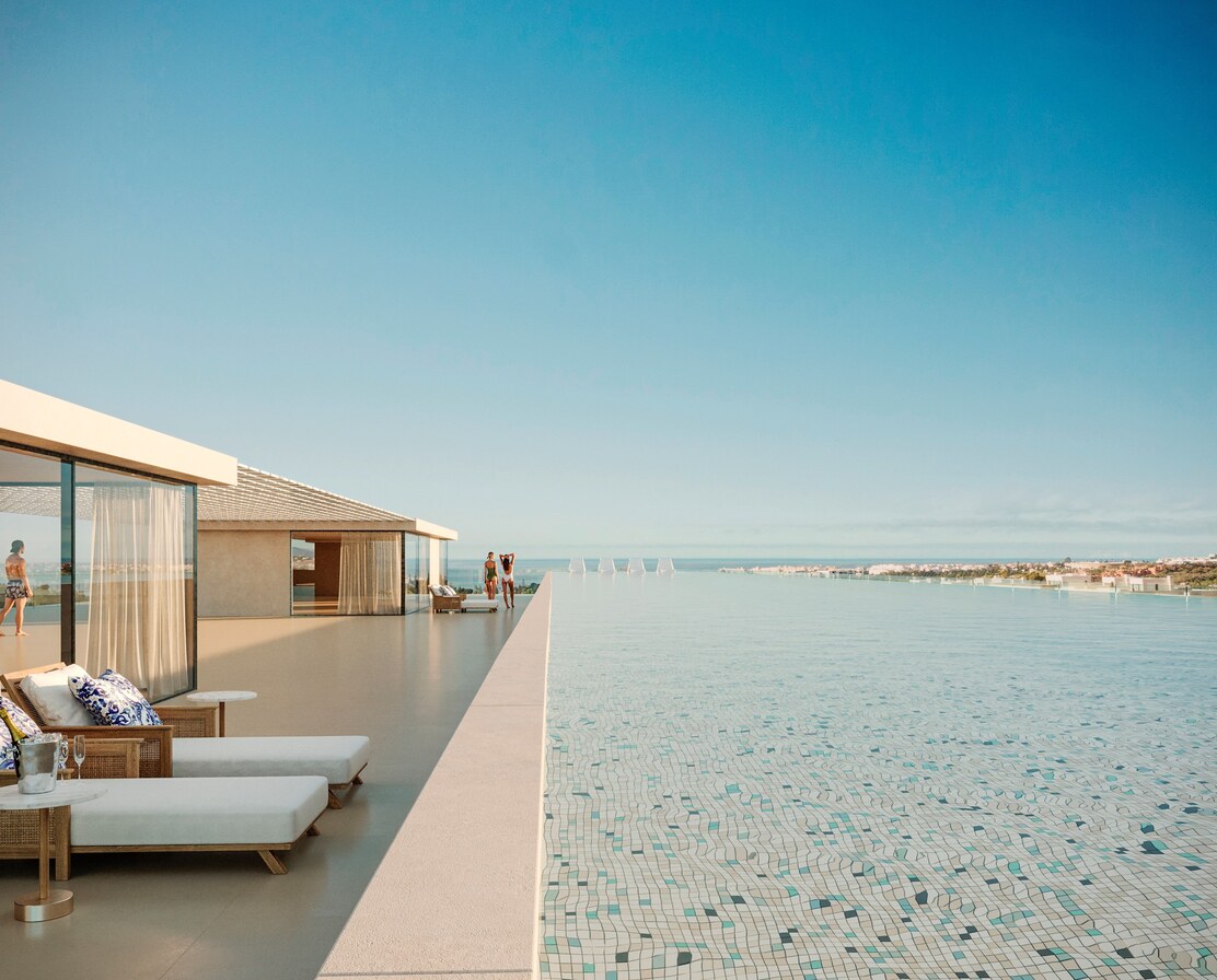 A penthouse rooftop pool with loungers along its edge, the sea beyond.